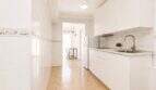 Helle Küche mit weißen Schränken, Marmoroptik-Rückwand und modernem Waschbecken im Penthouse Palma de Mallorca