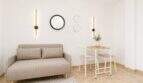 Helles Wohnzimmer im Penthouse Palma mit Zweisitzer-Sofa, Esstisch und modernen Wandleuchten