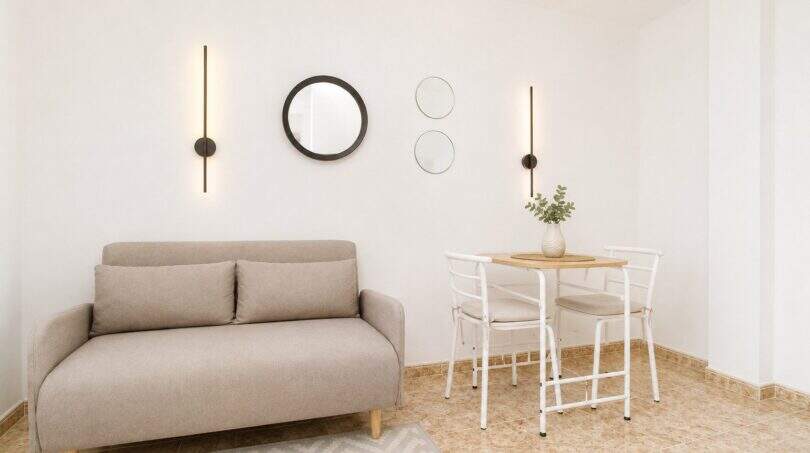 Helles Wohnzimmer im Penthouse Palma mit Zweisitzer-Sofa, Esstisch und modernen Wandleuchten