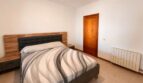 Schlafzimmer der Finca Sencelles mit Doppelbett, Holzkopfteil, Heizkörper und Holztür