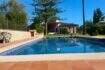 Finca Sencelles: Großer blauer Pool mit Terrakottaboden, Natursteinmauer und mediterranem Landhaus im Hintergrund.