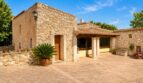 Rustikale Finca bei Sencelles: Innenhof mit Natursteinmauern, überdachter Terrasse und mediterraner Bepflanzung.