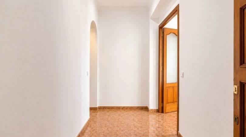 Heller Flur mit Bogennische, Terrakottafliesen und Holztüren in moderner Wohnung in Palma-Camp Redó