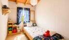Kinderzimmer der Finca mit Holzbalkendecke, Weltraum-Deko, Elmo-Plüschtier und buntem Spielzeugrega
