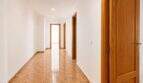Bright hallway of the apartment in Palma with marble floor, white walls and wooden doors