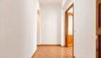 Bright hallway of the apartment in Palma with arched niche, terracotta tiles and wooden doors