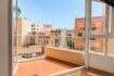 Heller Balkon mit Fliesenboden und weißem Geländer, Blick auf sonnige Stadtgebäude in Palma de Mallorca