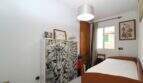 Kleines Schlafzimmer im Stadthaus Portixol mit Einzelbett, Kommode mit Leoparden-Motiv und Wanddeko.