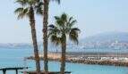 Meerblick vom Stadthaus in Portixol mit Palmen, türkisem Wasser und Hafenmole in Palma de Mallorca.