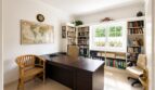 Helles Arbeitszimmer mit dunklem Schreibtisch, Weltkarte, Bücherregalen und Fenster zur Gartenansicht in Doppelhaushälfte Llucmajor