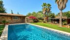 Pool mit Natursteinhaus, Palmen und üppigem Garten der Finca bei Llucmajor