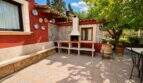 Covered terrace of the Llucmajor finca with grill fireplace, mosaic tiles and Mediterranean garden