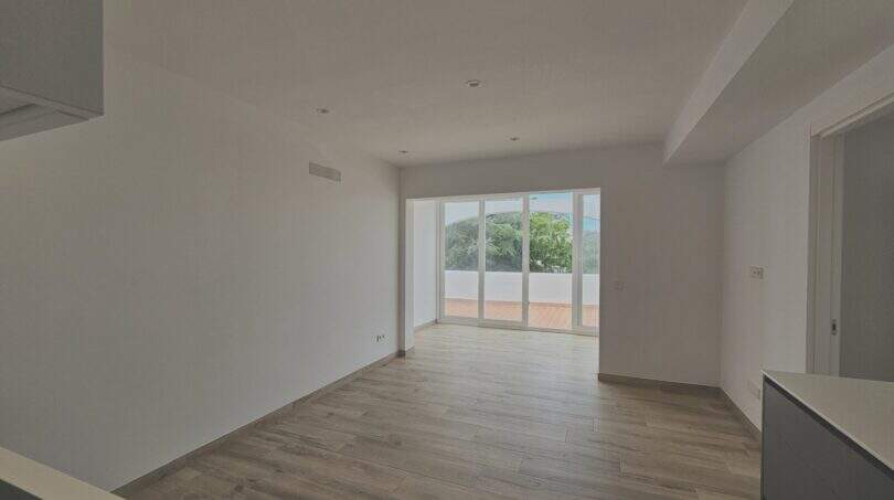 Heller Wohn-Essbereich mit Holzboden und großer Glasfront zum Balkon, Neubau-Apartment Cala d'Or