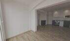 Helles Wohnzimmer mit Holzboden und offener moderner Küche in Erstbezug-Apartment Cala d'Or