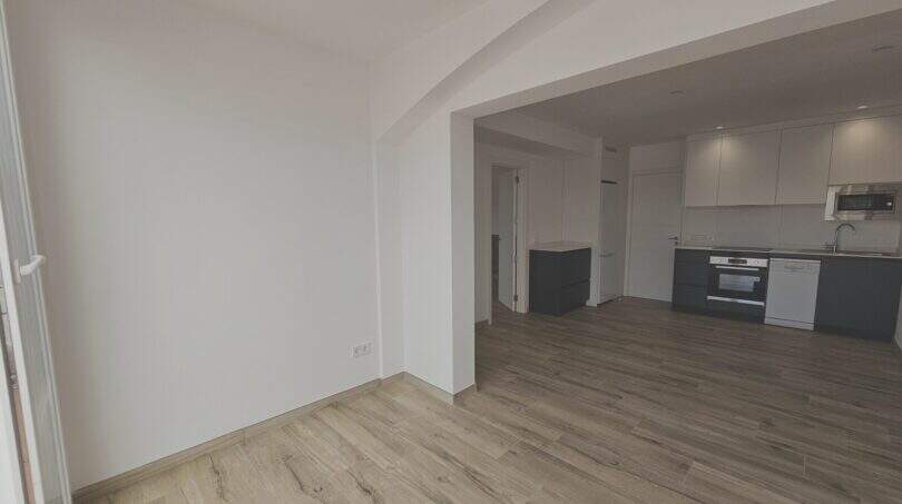 Helles Wohnzimmer mit Holzboden und offener moderner Küche in Erstbezug-Apartment Cala d'Or