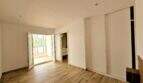 Helles Schlafzimmer mit Holzboden, Einbauschrank, Terrassenzugang und angrenzendem Bad in Erstbezug-Apartment Cala d'Or.