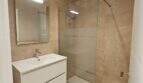 Modernes Badezimmer der Erstbezug-Wohnung in Cala d'Or mit Walk-in-Dusche, schwebendem Waschtisch und Holzoptikboden.