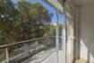 Moderner Balkon mit Glasgeländer und Blick auf grüne Pinien, Wohnung in Palma mit Tiefgarage.