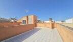 Geräumige private Dachterrasse mit Fliesenbelag und Blick über die Dächer von Porto Cristo unter blauem Himmel.