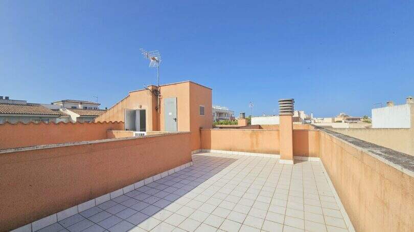 Geräumige private Dachterrasse mit Fliesenbelag und Blick über die Dächer von Porto Cristo unter blauem Himmel.