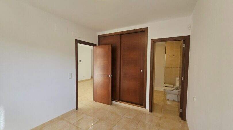Helles leeres Schlafzimmer mit Einbauschrank, En-Suite-Bad und Fliesenboden in Wohnung in Porto Cristo