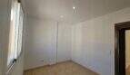 Leeres, helles Schlafzimmer mit Fliesenboden, Einbauspot und Fenster in Wohnung mit Dachterrasse in Porto Cristo