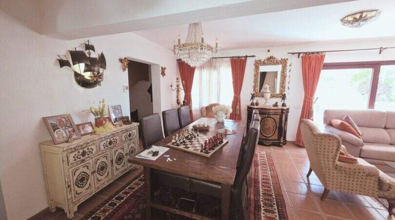 Elegantes Wohnzimmer mit Kristallleuchter, Schachtisch, Orientteppich und mediterranem Flair im Traumhaus Cala Romántica