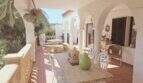Überdachte Terrasse mit Bogengängen, rustikalem Esstisch und Meerblick des mediterranen Traumhauses in Cala Romántica.