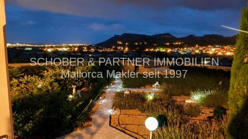 Illuminated garden at night with panoramic view of Son Servera and mountain silhouette, Mallorca property
