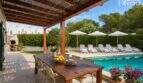 Überdachte Terrasse mit Esstisch, Salzwasserpool und Sonnenliegen im gepflegten Garten des Bungalows in Alcúdia.