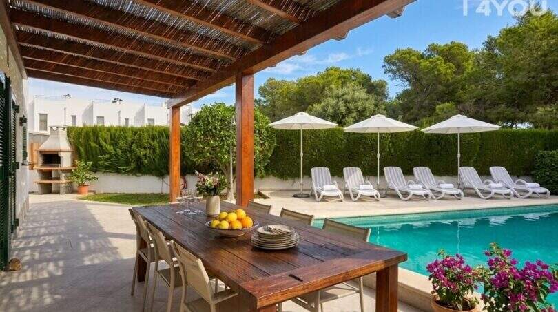 Überdachte Terrasse mit Esstisch, Salzwasserpool und Sonnenliegen im gepflegten Garten des Bungalows in Alcúdia.