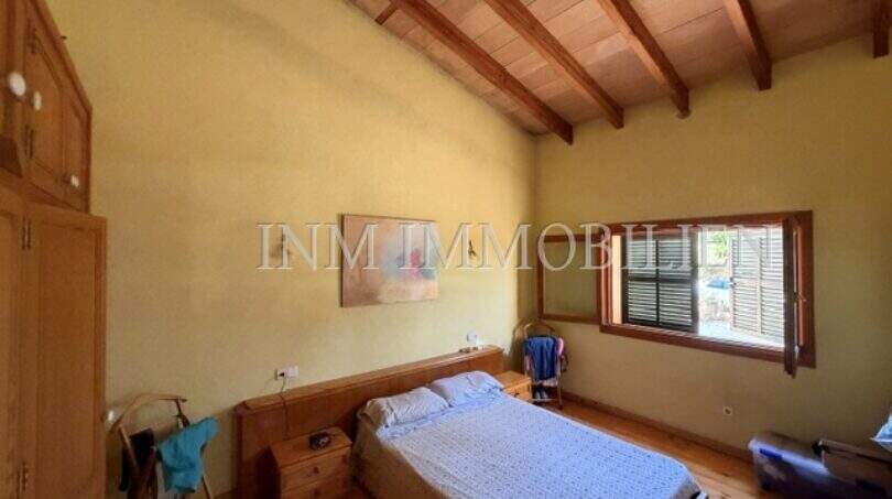 Schlafzimmer der Finca Llucmajor mit Holzbalkendecke, Doppelbett und Holzboden