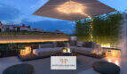 Beleuchtete Dachterrasse des Penthouse Cor 39 in Palma mit Loungemöbeln, Sonnenschirm und Bambus bei Abenddämmerung.