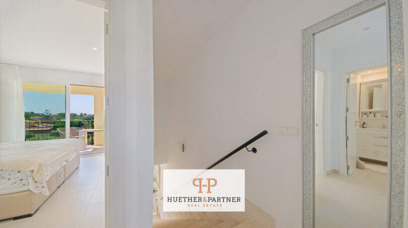 Heller Treppenabsatz mit Blick ins Schlafzimmer und Badezimmer, modernes Reiheneckhaus in Porto Cristo Novo.