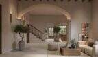 Elegantes Wohnzimmer mit Bogendurchgang, Olivenbäumen, Holztreppe und mediterranem Charme im Stadthaus Felanitx