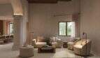 Elegantes Wohnzimmer mit Säulen, Holzbalkendecke, cremefarbenen Sofas und natürlichem Lichteinfall in Stadthaus Felanitx