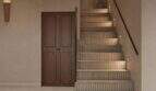 Eleganter Eingangsbereich mit Natursteintreppe, integrierter Beleuchtung und Holztür im renovierten Stadthaus Felanitx