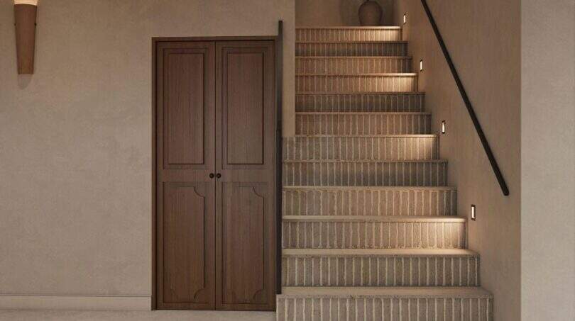 Eleganter Eingangsbereich mit Natursteintreppe, integrierter Beleuchtung und Holztür im renovierten Stadthaus Felanitx