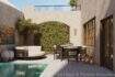 Mediterraner Innenpatio mit Pool, Loungebereich, Esstisch und begrünter Arkadenwand eines Stadthauses in Felanitx.