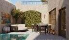 Mediterraner Innenpatio mit Pool, Loungebereich, Esstisch und begrünter Arkadenwand eines Stadthauses in Felanitx.
