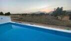 Finca Campanet: Blauer Pool mit Blick auf Olivenhain und Bergpanorama im Abendrot