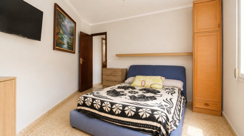Dormitorio del apartamento de playa en Palma con cama doble, armario empotrado, TV y ventilador de techo