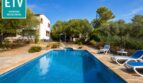 Außenpool mit Liegestühlen, weißer Finca und mediterranem Garten der Ferienvilla in Marratxí