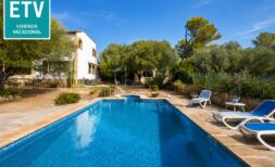 Außenpool mit Liegestühlen, weißer Finca und mediterranem Garten der Ferienvilla in Marratxí