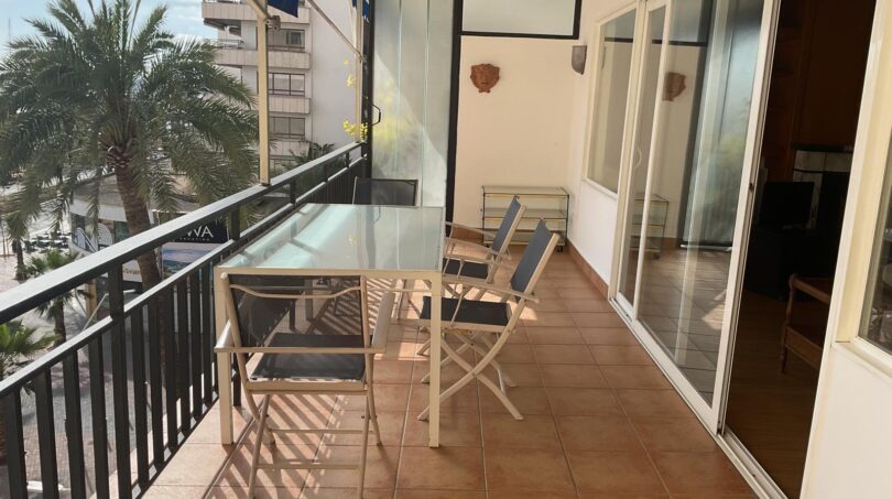 Sonnige Terrasse mit Glastisch und Stühlen, Blick auf Palmen und Promenade, Wohnung am Paseo Marítimo Palma