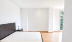 Helles Schlafzimmer mit dunklem Doppelbett, Parkettboden und großem Fenster in exklusiver Wohnung in Palma