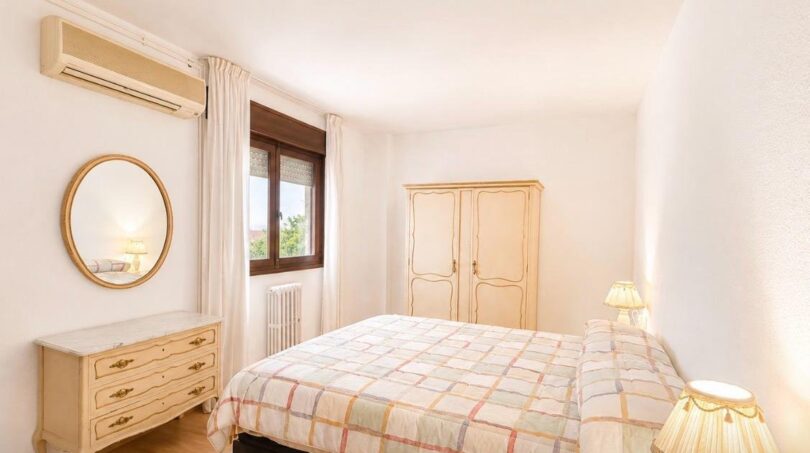 Helles Schlafzimmer mit Doppelbett, Vintage-Kommode, Spiegel, Einbauschrank und Klimaanlage in Palma-Wohnung