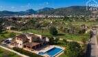 Luftaufnahme mallorquinischer Finca in Lloseta mit Pool, Terrasse und Blick auf Tramuntana-Gebirge.