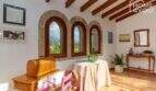 Helles Wohnzimmer mit Natursteinbögen, Holzbalkendecke & Tramuntana-Blick der mallorquinischen Villa