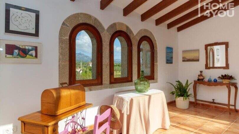 Helles Wohnzimmer mit Natursteinbögen, Holzbalkendecke & Tramuntana-Blick der mallorquinischen Villa